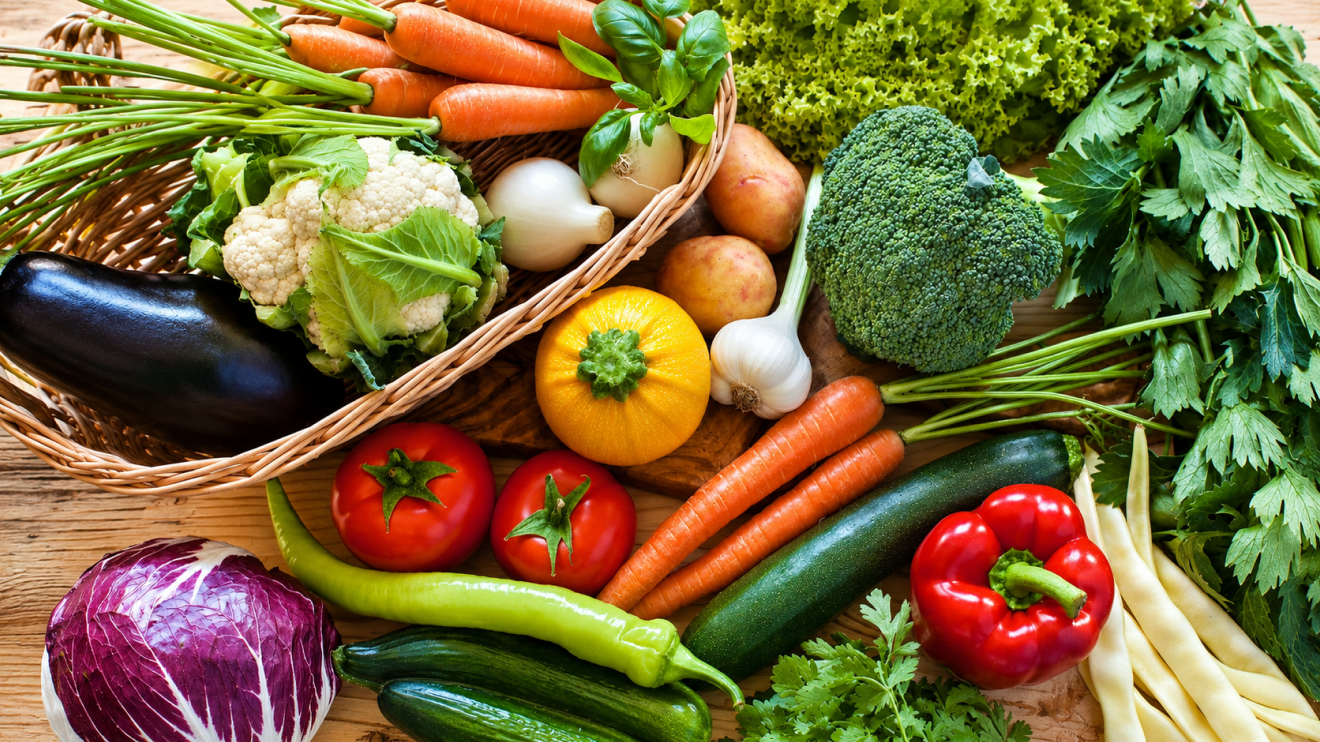 10 Foods To Eat More Often To Support Healthy Aging 6 Colorful Assortment Of Fresh Vegetables On A Wooden Table, Including Carrots, Cauliflower, Broccoli, Tomatoes, Zucchini, Eggplant, Onions, Garlic, Lettuce, Parsley, Peppers, Cucumbers, And Radicchio, With Some Arranged In A Wicker Basket.