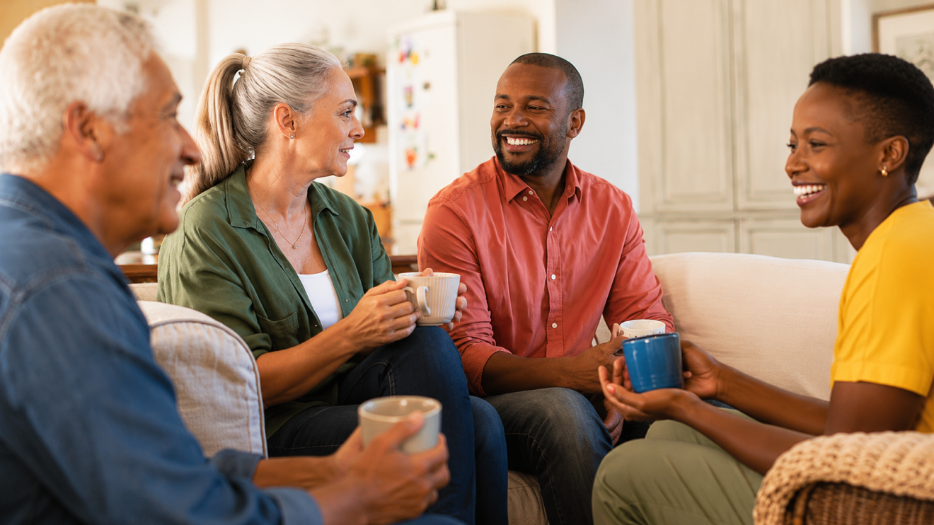 What Healthy Aging Really Looks Like (And What It Doesn'T) 4 Four Adults Of Different Ages Smiling And Talking Over Coffee In A Bright, Comfortable Living Room.