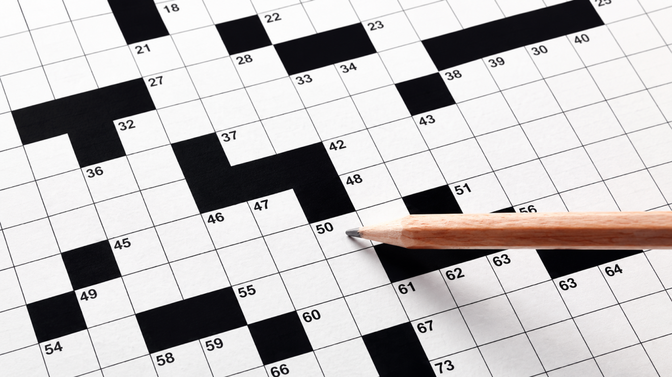 What Healthy Aging Really Looks Like (And What It Doesn'T) 5 Close-Up Of A Blank Crossword Puzzle Grid With Numbered Squares And A Wooden Pencil Resting Across The Page.