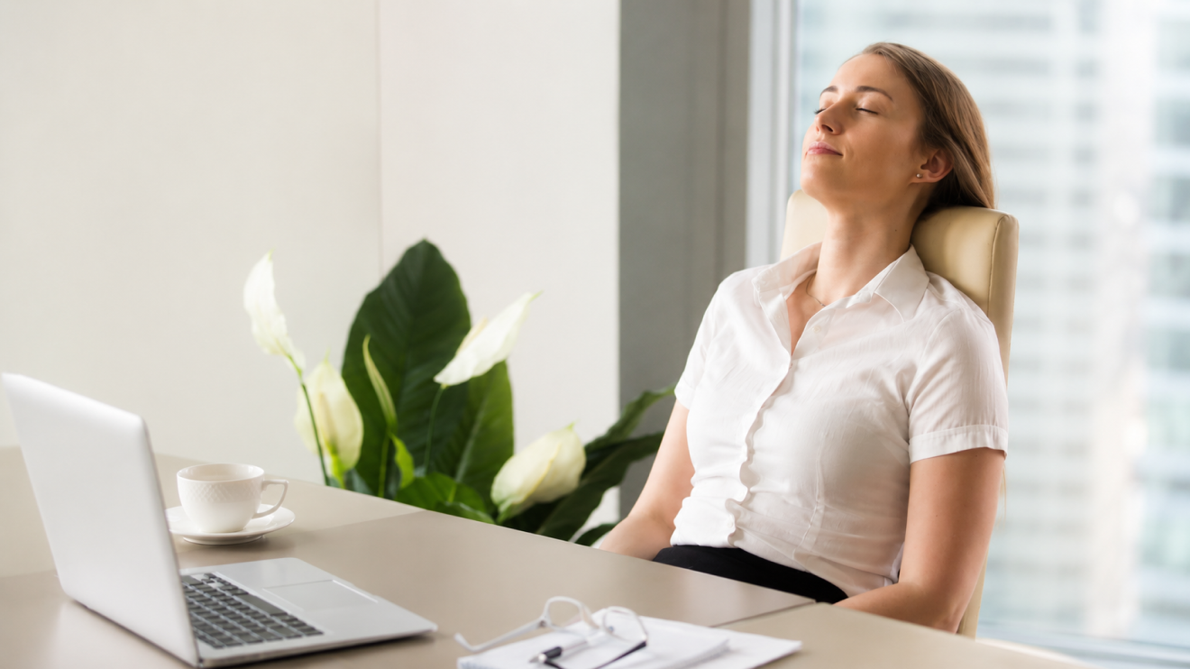 Brain Fog Fix: 7 Proven Strategies To Think Clearly Again 6 Woman Leaning Back In Her Office Chair With Eyes Closed, Practicing Mindfulness And Relaxation During A Work Break At A Bright Modern Office Desk.