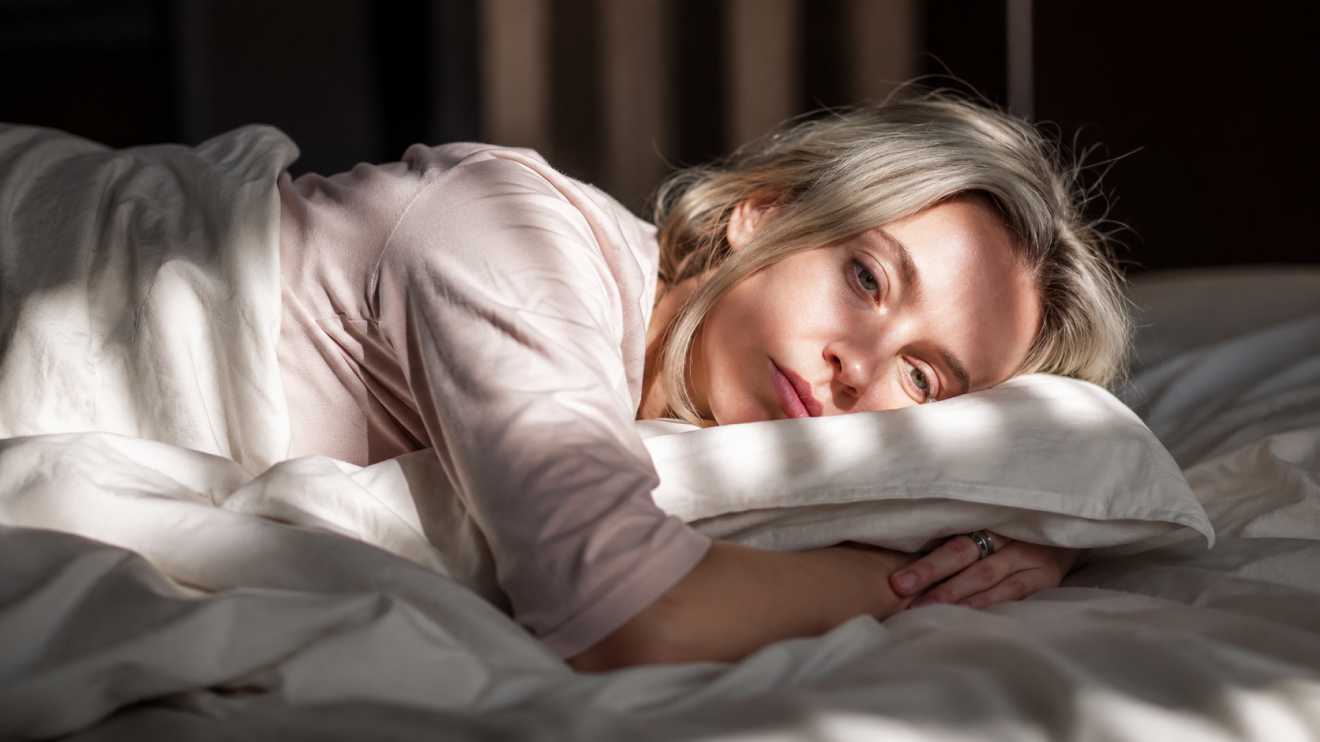 Brain Fog Fix: 7 Proven Strategies To Think Clearly Again 5 Woman Lying Awake In Bed With A Tired, Pensive Expression, Illustrating Sleep Disturbances And Fatigue Associated With Perimenopause.